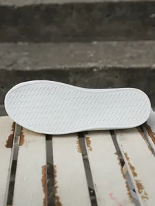 Detailed view of the anti-slip wavy pattern on a white platform casual shoe rubber sole