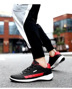 Side view of black and red leather men's running sneakers on an urban street background