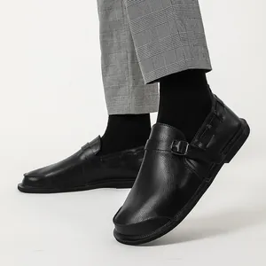 Detail shot of men's wide-toe retro black leather shoes worn with plaid trousers.