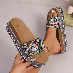 Primer plano de sandalias étnicas con plataforma, cuentas de colores y finas perlas