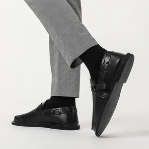 Macro detail of men's black vintage leather casual shoes featuring side buckle design