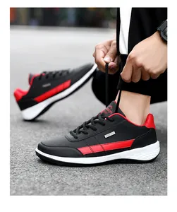 Detailed side view of black leather outdoor sneakers with red accents and white sole