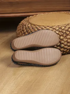 Detailed view of the non-slip striped sole and contrast stitching on wedge flip flops.