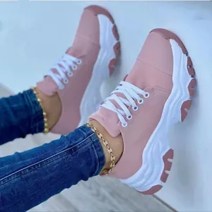 Close-up view of women's pink and white platform sneakers featuring stylish gold anklet