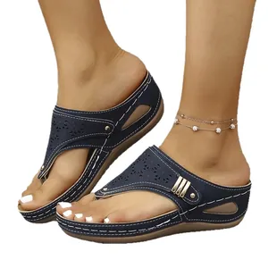 Sandalias de cuña azul marino con calados láser y elegantes remaches dorados