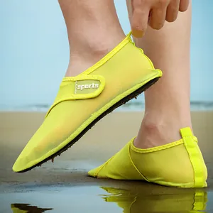 Close-up of neon green mesh water shoes for beach and swimming activities on sand