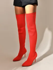 Vue macro détaillée de bottes hautes rouges en tricot extensible avec talons aiguilles