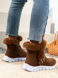 Gros plan de bottes d'hiver marron chaud avec bordure en fausse fourrure et semelle plate blanche