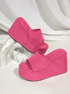 Vibrant hot pink platform wedge slides for women with a soft fabric upper and high heel