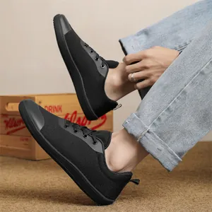 Detailed view of black breathable knit barefoot shoes with wide toe box on a model
