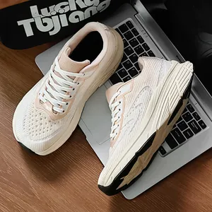 Detailed view of breathable beige mesh running shoes with wide toe box placed on a laptop keyboard