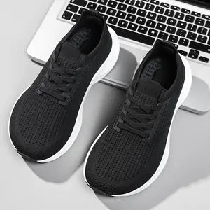 Detailed top view of black breathable fly-knit mesh running shoes with white soles