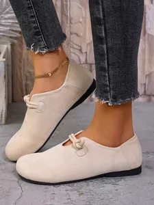 Primer plano de bailarinas de ante beige con detalle de nudo de cuerda único al pie