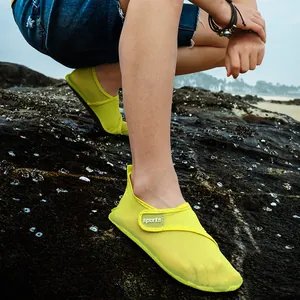 Lightweight lime green quick-dry water shoes for beach and swimming shown on rocks