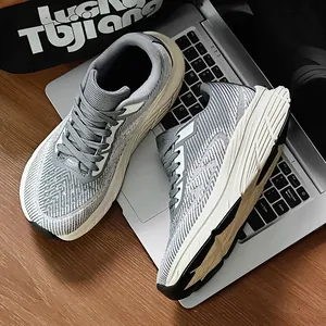 Close-up view of gray wide-toe breathable flyknit running shoes on a laptop background
