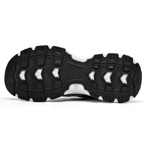 Detailed macro view of the rugged black and white non-slip outsole of a retro chunky sneaker