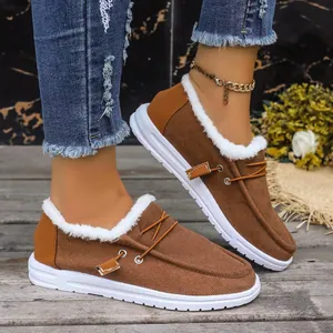 Macro detail of warm brown canvas women's loafers featuring white faux fur lining and thick soles