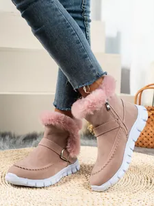 Détail de bottines d'hiver roses pour femmes avec bordure en fourrure et semelle blanche