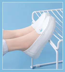 Close-up of white breathable nurse shoes with soft non-slip sole and heart logo detail