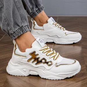 Detailed view of stylish white and gold chunky dad sneakers worn with grey casual joggers
