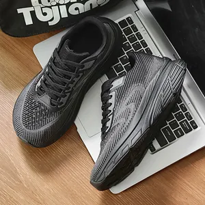 Detailed top-down view of black breathable flyknit running shoes for wide feet on a laptop