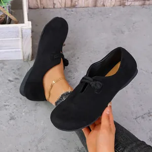 Vista detallada de mocasines negros de ante para mujer con un elegante detalle de nudo.