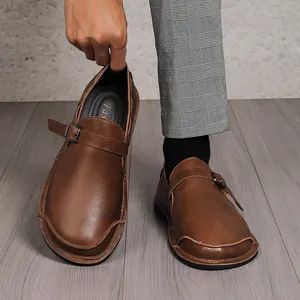 Close-up of brown leather wide toe shoes for men showing textured finish and buckle strap