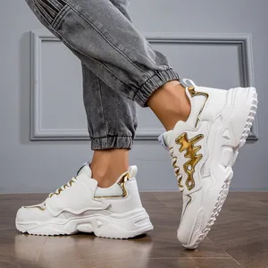Close-up of white men's chunky sneakers with stylish gold accents on the side