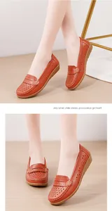Detailaufnahme von orangefarbenen, gelochten Leder-Loafers mit weicher Keilsohle für Damen