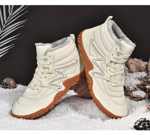 Close-up of stylish cream-colored high-top snow boots with cozy grey faux fur lining