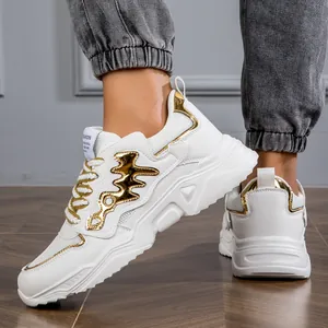 Detailed close-up of white chunky sneakers with gold metallic accents and thick rubber soles.