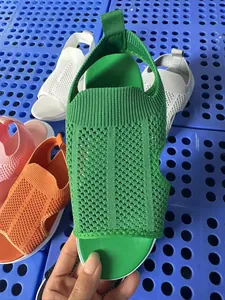 Nahaufnahme einer grünen, atmungsaktiven Mesh-Strick-Keilsandale mit offenem Zehendesign