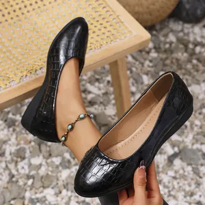 Close-up of stylish black crocodile texture women's wedge flats with a comfortable sole