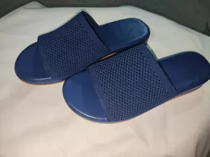 Detail view of breathable navy blue fly-knit fabric on lightweight slide sandals
