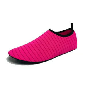 Scarpe da acqua rosa vibrante ad asciugatura rapida per spiaggia e yoga, sfondo bianco.