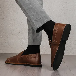 Detail view of stylish brown retro leather loafers with wide toe box and flat black sole.