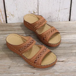 Détail de mules compensées romaines marron avec brides brodées et bout ouvert peep-toe.