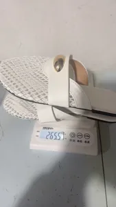 Detailed view showing the weight of white mesh flat mules for women on a digital scale