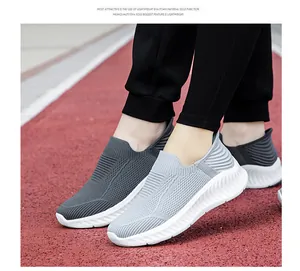 Detailed close-up of breathable fly-knit slip-on walking shoes on a red running track