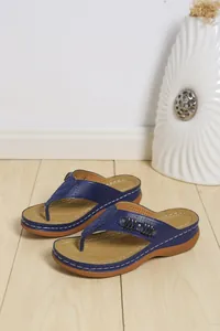 Dettaglio laterale di infradito platform blu navy con cinturini in pelle traforata