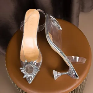 Gros plan d'élégantes sandales à talons hauts en cristal avec boucle soleil en strass