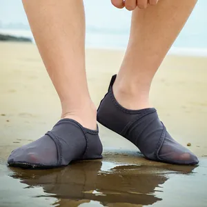 Detailed view of breathable mesh water shoes worn on a sandy beach by the sea