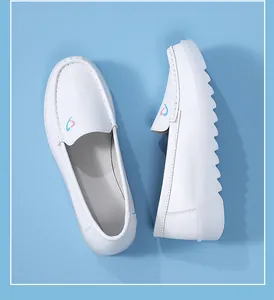 Detailed view of white nursing shoes featuring heart embroidery and a thick non-slip sole