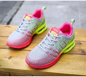 Macro view of stylish grey and pink women's mesh running shoes with EVA air cushion soles.