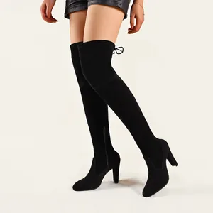 Gros plan de bottes cuissardes noires avec bout pointu et fermeture éclair latérale