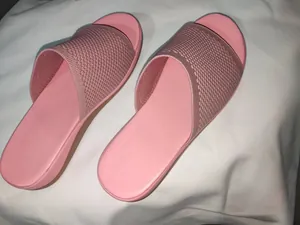 Close-up view of the comfortable pink fly-knit upper on casual soft flat sandals for women