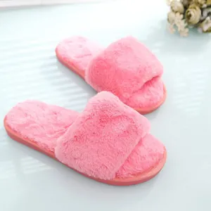 Soft pink fuzzy open-toe indoor slippers for women in a bright home setting