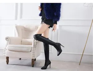 Elegant black pointed toe over-the-knee boots with stiletto high heels shown on a model.