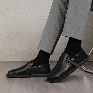 Detailed view of vintage black leather wide-toe men's shoes featuring a buckled monk strap