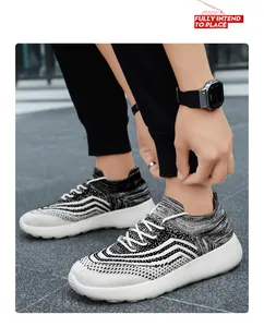 Close-up of men's breathable black and white knitted sneakers worn on a street background